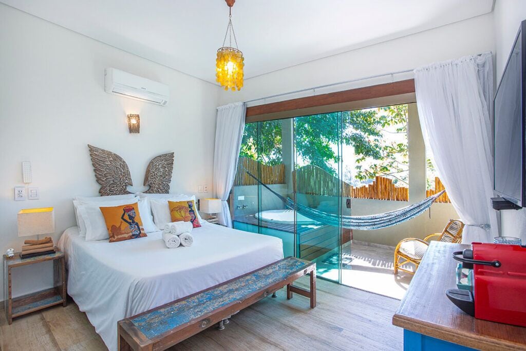 A bedroom with a bed, bedside table, and a hammock.