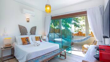 A bedroom with a bed, bedside table, and a hammock.