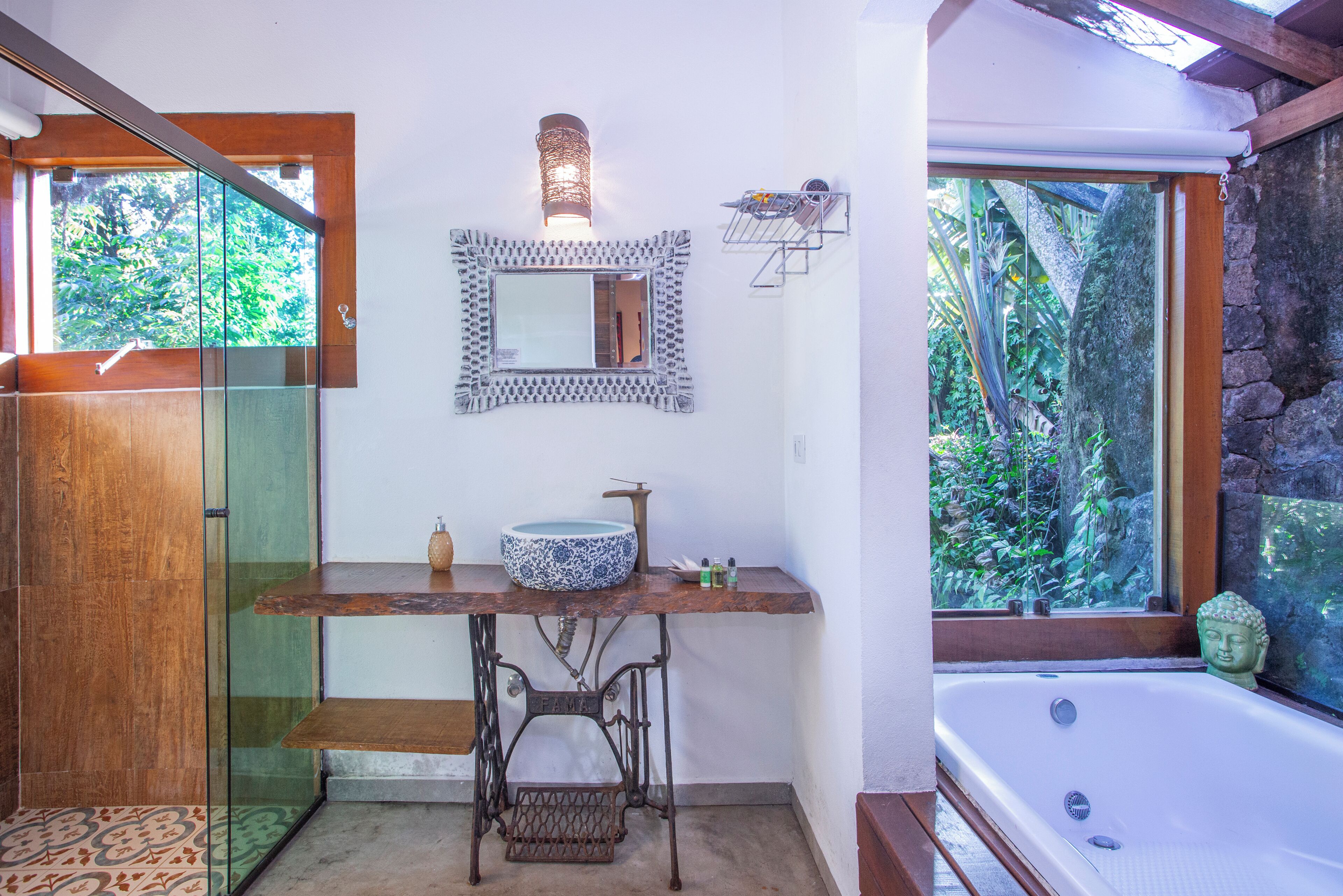 A bathroom with a large bathtub, a sink with a decorative bowl, a mirror, and a shower area.
