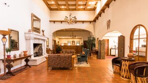 A spacious lobby with a fireplace, seating area, and a large chandelier.