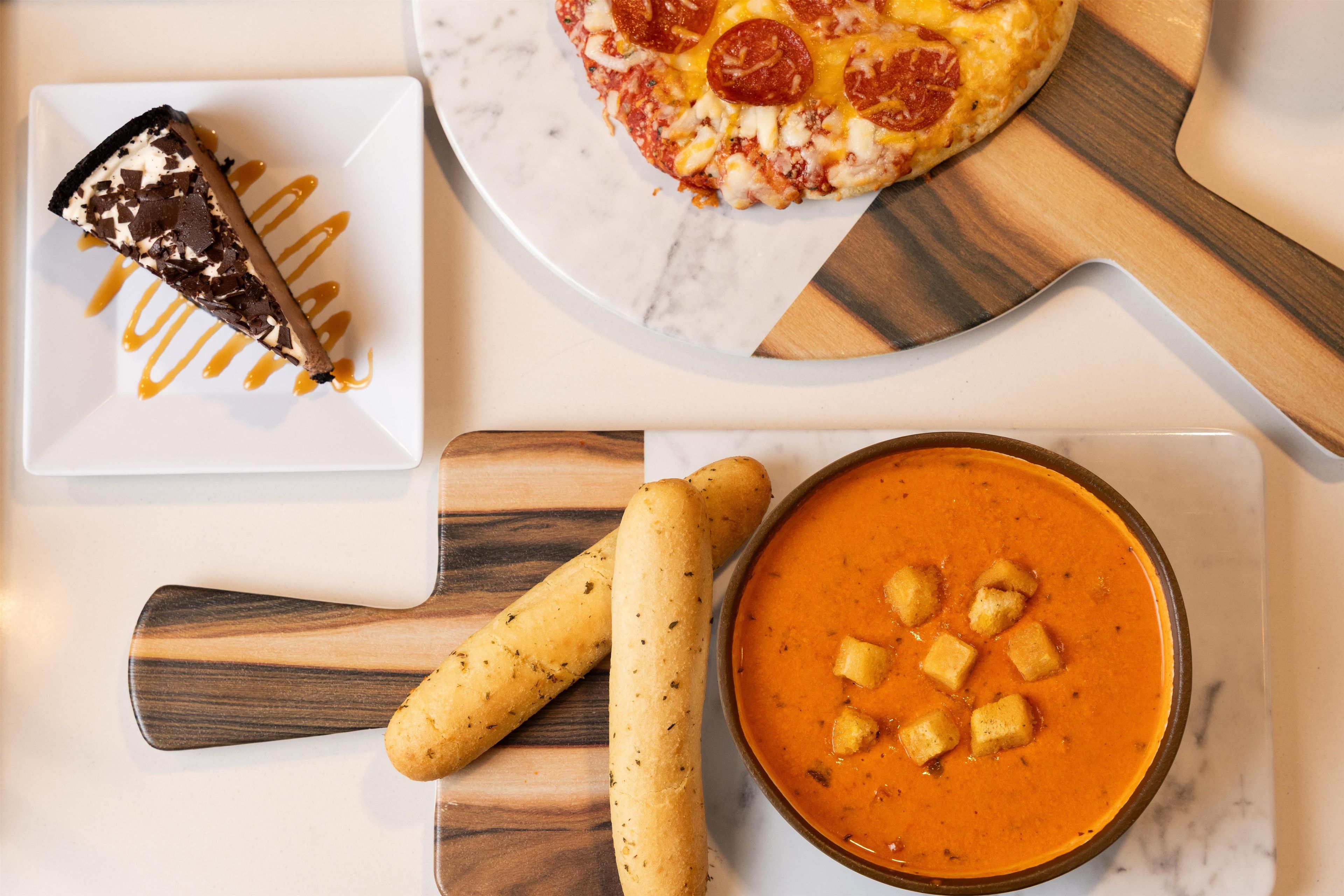 A dessert plate with a chocolate tart and a pizza with pepperoni.