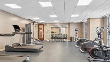 A gym with treadmills, elliptical machines, and free weights.