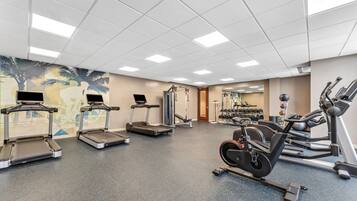 A gym with treadmills, elliptical machines, and weightlifting equipment.