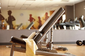 A gym with exercise equipment, including a bench and weights, and a mirror reflecting the room. - Hyatt House Orlando International Drive (Orlando)