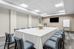A conference room with a long table, chairs, a whiteboard, and a flat-screen TV on the wall. - Hyatt House Orlando International Drive (Orlando)