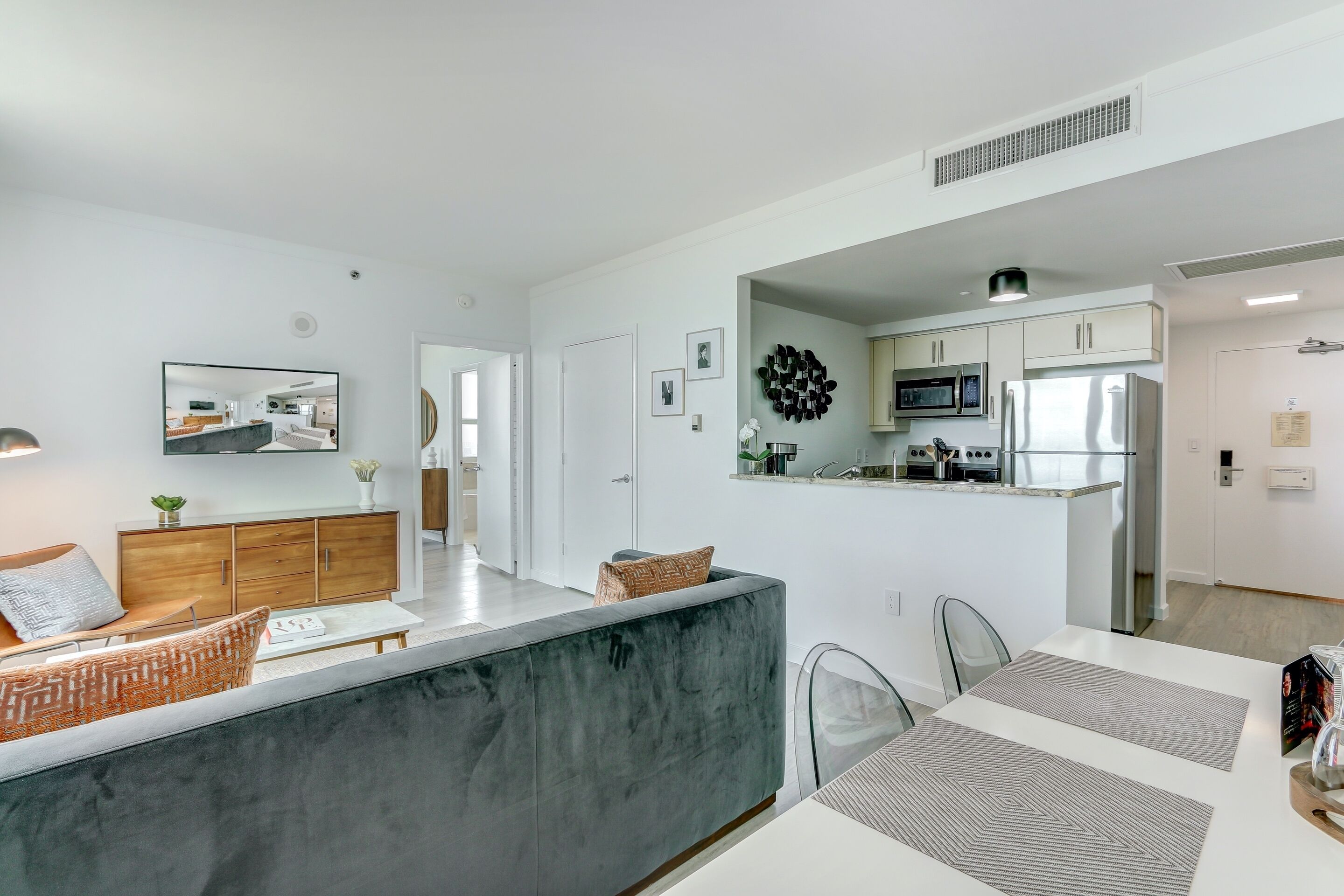 A modern kitchen with a microwave, refrigerator, and a small island.