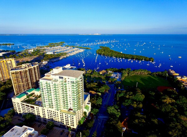 An aerial view of a coastal area with a marina, buildings, and a golf course. - iCoconutGrove Vacation Rentals (Miami)