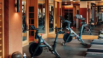 Un gimnasio con bicicletas estáticas, espejos y equipamiento de ejercicio.