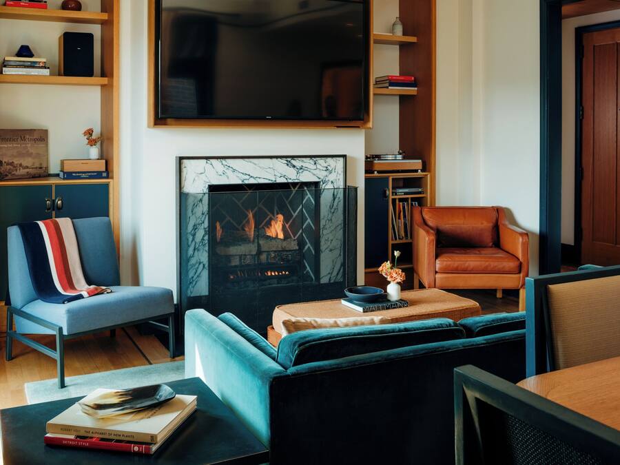 A modern living room with a fireplace, seating, and a television.