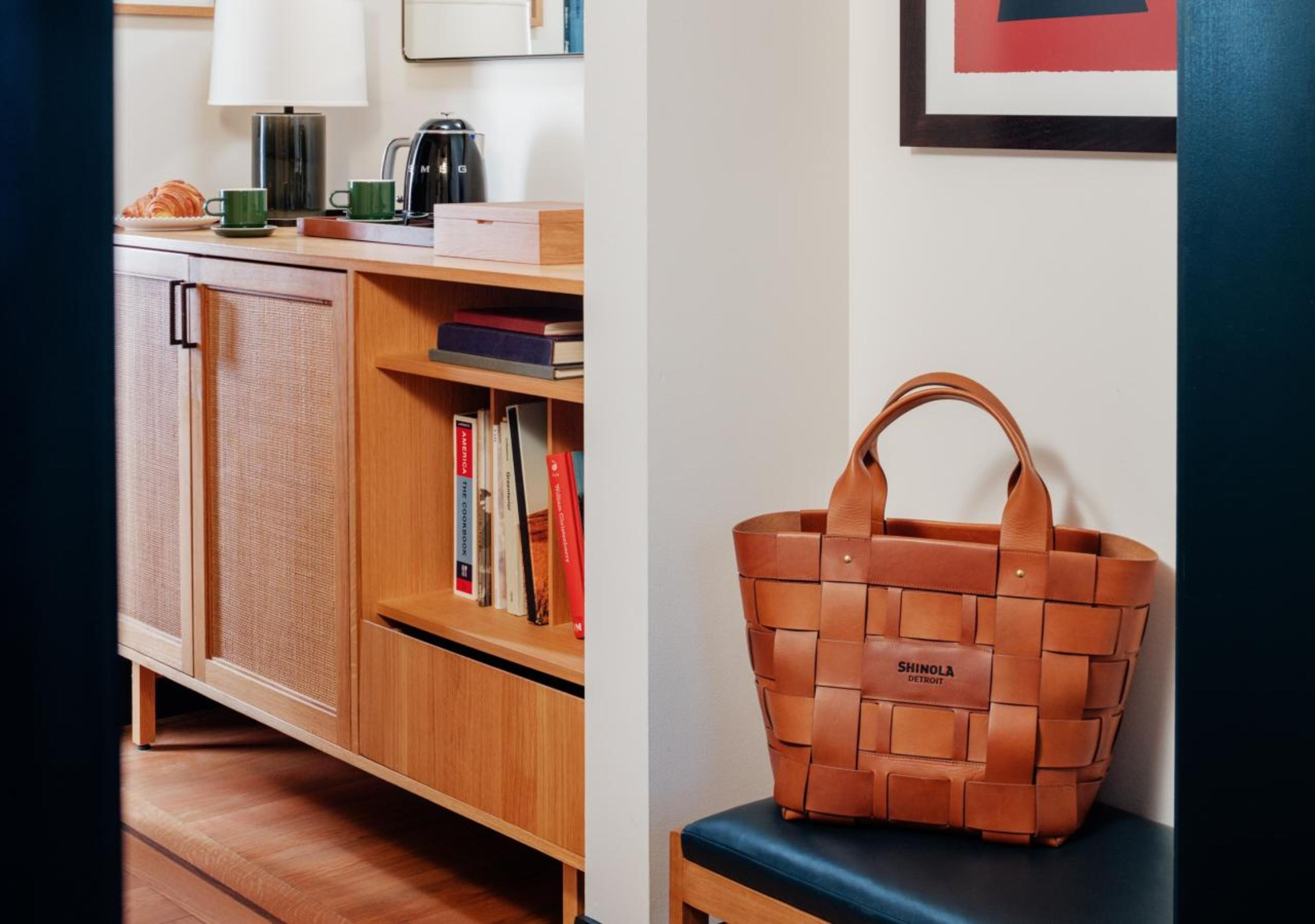 A room with a wooden cabinet, a bookshelf, and a woven basket on a chair.