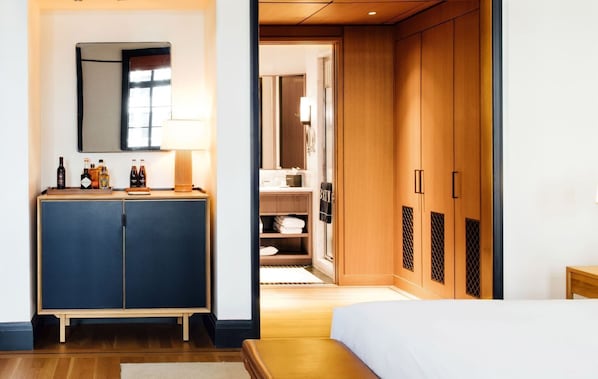 Relax in a spacious room with a large bed, nightstand, and wardrobe, plus a cozy seating area.