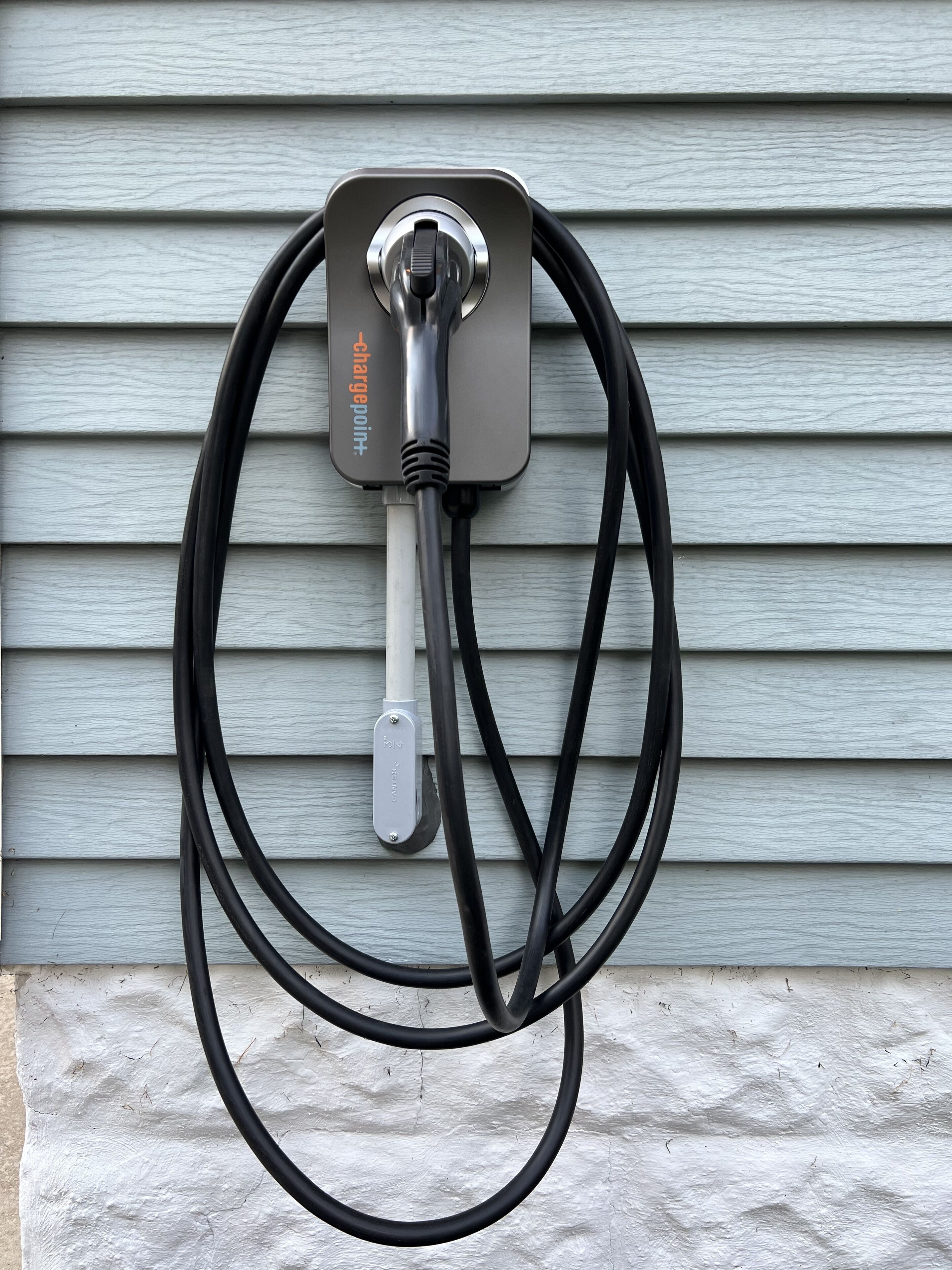 A wall-mounted charging station with a cable.