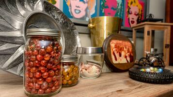 A wooden table with jars of marbles, a brass container, and a bicycle.