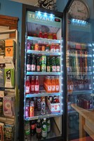 A vending machine stocked with various beverages including sodas, sparkling juices, and iced teas.