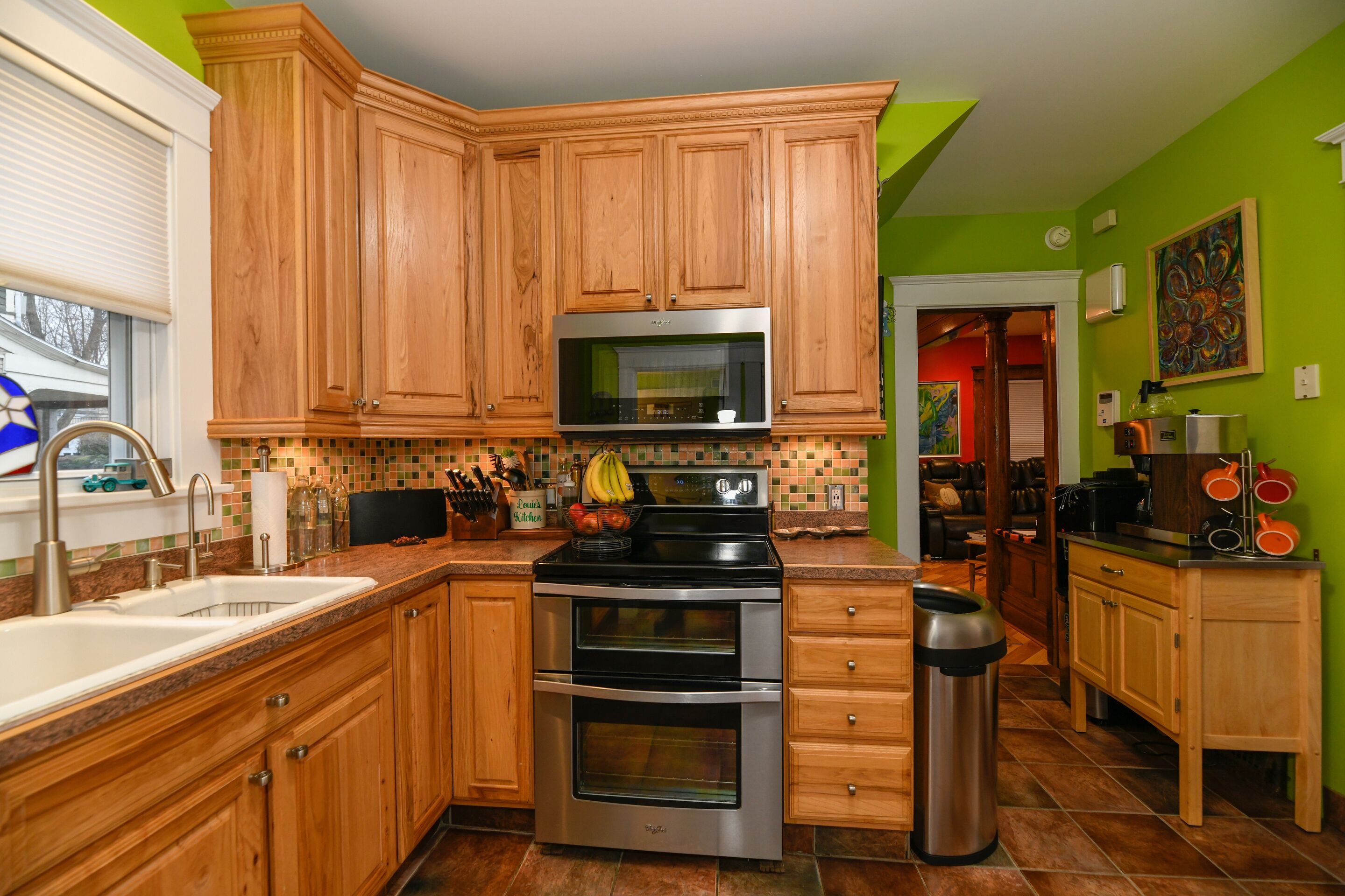 A kitchen with wooden cabinets, a stainless steel microwave, and a double oven.