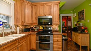 A kitchen with wooden cabinets, a stainless steel microwave, and a double oven.