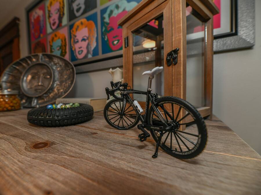 Uma mesa de madeira com uma bicicleta, um pneu e pratos decorativos.