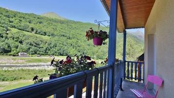 A balcony with a view of a green valley and hills.