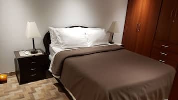 Escritorio, cortinas blackout y tabla de planchar con plancha