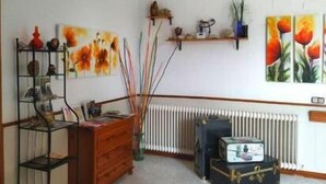 Ein Zimmer mit einem Holzkasten, einem Heizkörper und einem Regal mit Dekorationen.