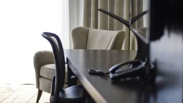 Une chambre d’hôtel équipée d’un bureau, d’une chaise et d’un téléviseur.