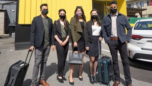 Un gruppo di persone in piedi davanti al cartello di PandaPodHotel.