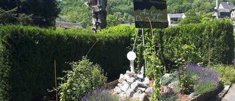A sign for a hotel and restaurant with a view of a mountainous landscape.
