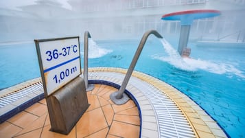 Ein Pool mit einem Hinweisschild für die Wassertemperatur, die 36 bis 37 Grad Celsius anzeigt, und einer angegebenen Tiefe von 1,00 Meter.
