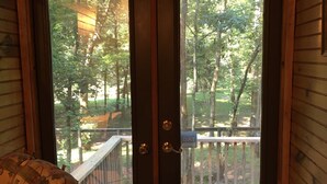 A wooden door with a view of a wooden deck and trees. - Merging Waters - Native Stone, couples cabin in the Ouachita Mts-with STARLINK (Smithville)