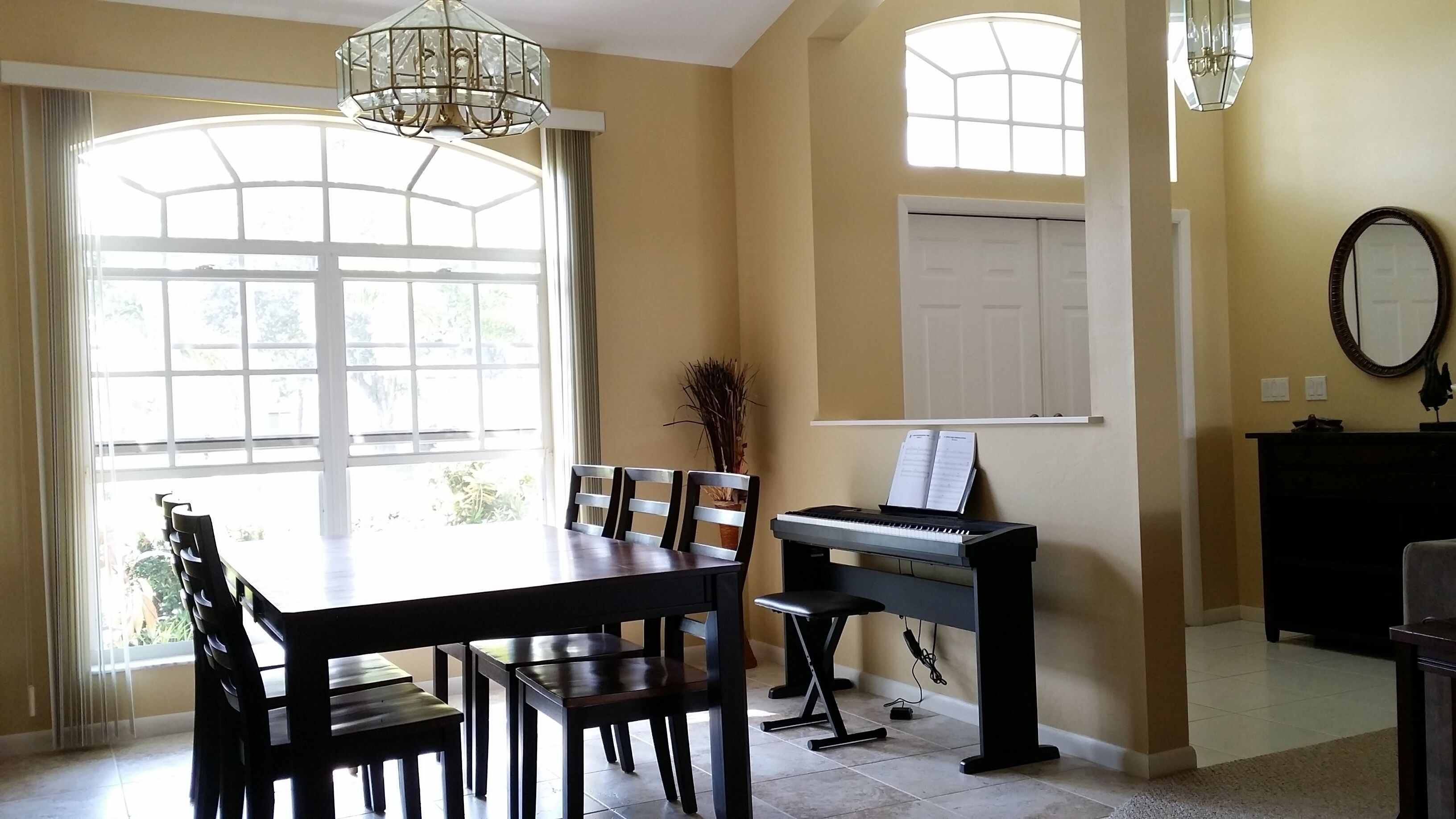 Un comedor con un piano, una mesa y sillas.