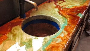 A kitchen with a colorful countertop, a sink, and a window with curtains. - WILLOW RUN LODGE  an Authentic Timber Frame Cabin on private 35 acres with river (Blakeslee)