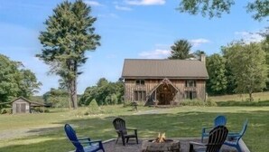 A rustic cabin with a fire pit and outdoor seating. - WILLOW RUN LODGE  an Authentic Timber Frame Cabin on private 35 acres with river (Blakeslee)
