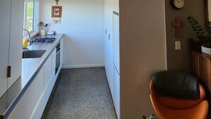 A narrow kitchen with a gas stove, sink, and window. There is a cross on the wall and a clock. -  Farm stay-Tranquil & quiet, relaxation country style (Sentry Hill)