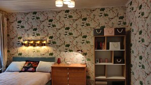 A bedroom with a bed, dresser, nightstand, and a bookshelf. - Väike-Kuke Dream Apartment (Pärnu)