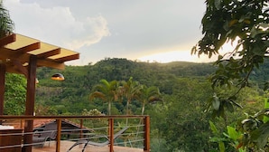 A wooden deck with lounge chairs, a pool, and a view of a lush green landscape. - Wonderful farmhouse in Bragança, a refuge close to São Paulo. (Chácaras Fernão Dias)