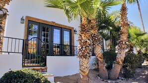 A white building with a black-framed window and a black railing.