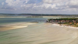 A coastal landscape with a sandy beach and a small settlement. - Beachfront apartment on Itamaracá Island/PE - Itaoca Residence Condominium (Ilha de Itamaracá)