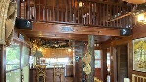 A wooden interior with a bar area, wooden furniture, and a staircase. - Private Island, FL Keys Entire Island, Home, A/C, Boat, Dock, Beach, Bikes, WiFi (Marathon)