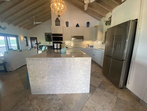 A spacious kitchen with a large island, modern appliances, and a view of the outdoors.