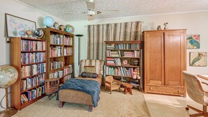 A cozy room with a large bookshelf, a globe, a desk, and a chair.