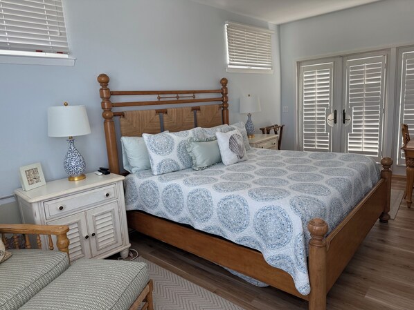 A bedroom with a wooden bed, a nightstand with a lamp, a dresser, and a chair. - Secluded and Private House with Pool, Near Beach. 11 blocks from Village. (Boca Grande)