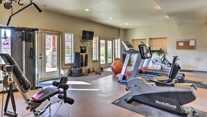Ein Fitnessstudio mit Laufbändern, Krafttrainingsgeräten und Übungsbällen.