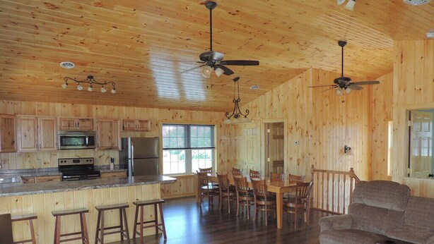 Una cabaña de madera espaciosa con cocina, comedor y sala de estar.