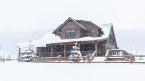 A wooden cabin with a snow-covered roof and a wooden deck in front. - GORGEOUS Home with Mtn Views/Perfect For Families & Groups/Wrap Porch/ATV Pking (Red River)