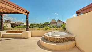 A rooftop patio with a hot tub, wooden pergola, and a view of surrounding buildings. - Resort-Style Condo 3 Miles to Historic Tulum Ruins (Tulum)