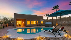 Una casa moderna con piscina, mobiliario de exterior y zona de patio.