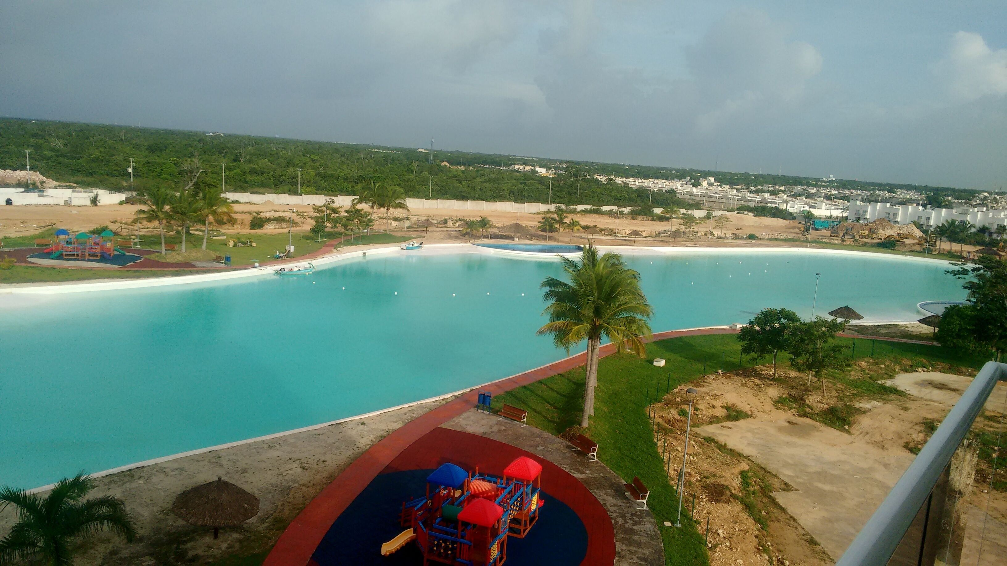 Vista di una grande piscina cristallina con un'area giochi in primo piano.