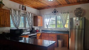 A kitchen with wooden cabinets, a stainless steel refrigerator, a stove, and a sink. - Newly Renovated. Less than 5 minutes walk  to the Beach!!! Free Hi Speed WiFi!! (Nassau)