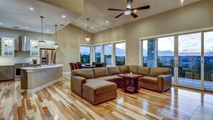 A spacious living area with a large sectional sofa, a dining table, and a kitchen with a central island.