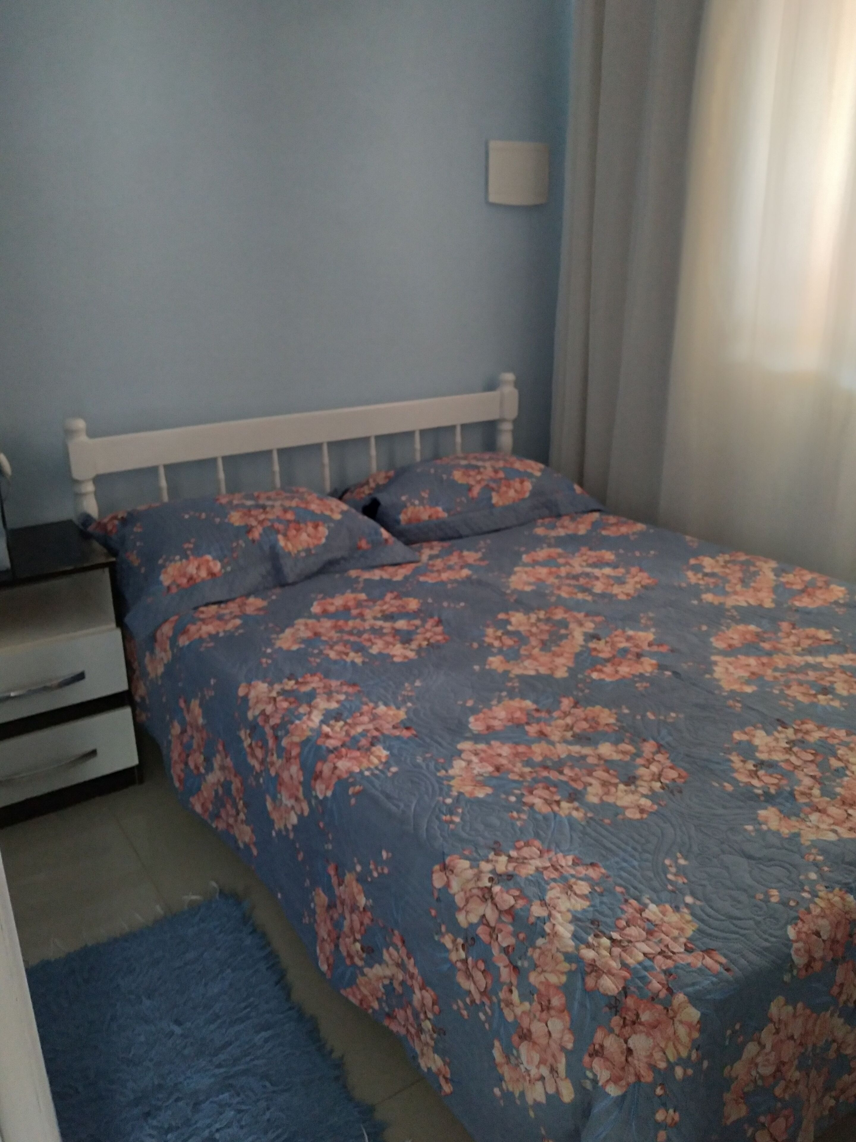 A bedroom with a bed, a nightstand, and a dresser.